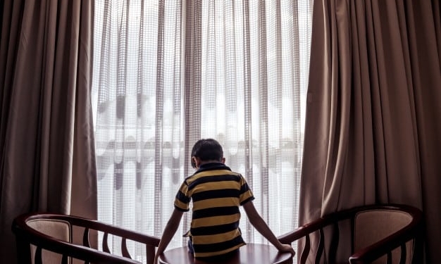 boy sitting table looking down down 1353 86