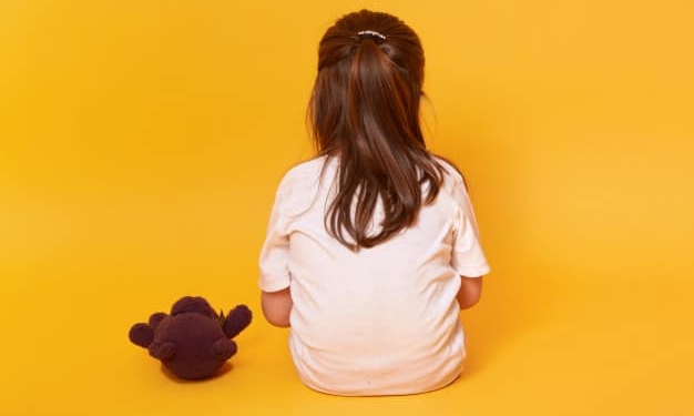 little girl sitting backwards with brown teddy bear 176532 8092