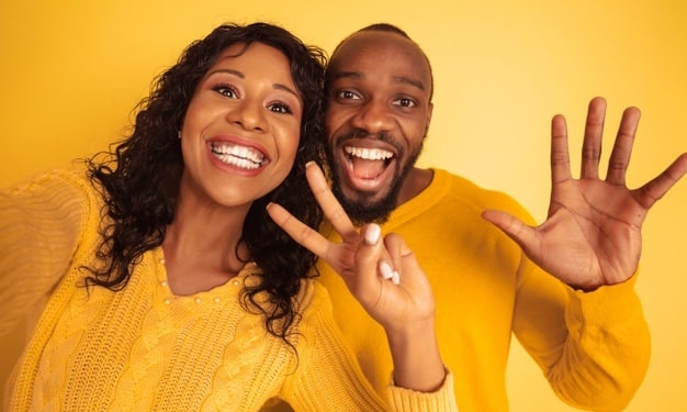 young emotional african american man woman bright casual clothes yellow background beautiful couple concept human emotions facial expession relations ad taking selfie together 155003 25648