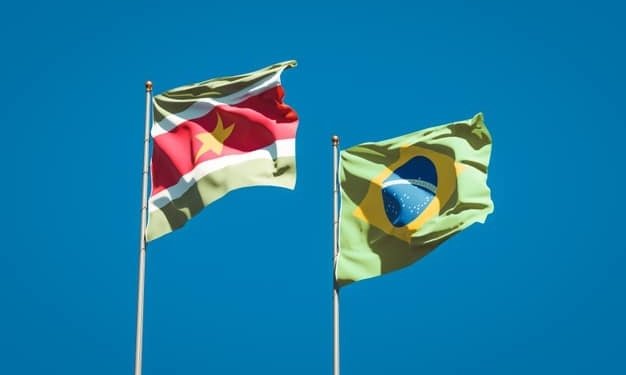 mooie nationale vlaggen van suriname en brazilie samen op blauwe hemel 337817 3084