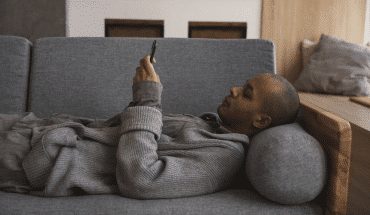 man thuis bank liggen telefoon mobiel | GFC
