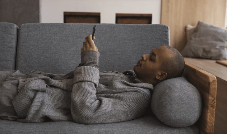 man thuis bank liggen telefoon mobiel | GFC