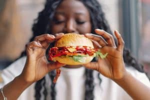 vrouw eten hamburger junkfood | GFC