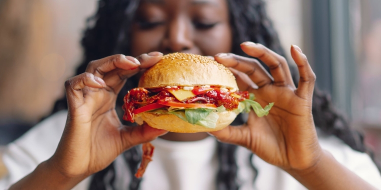 vrouw eten hamburger junkfood