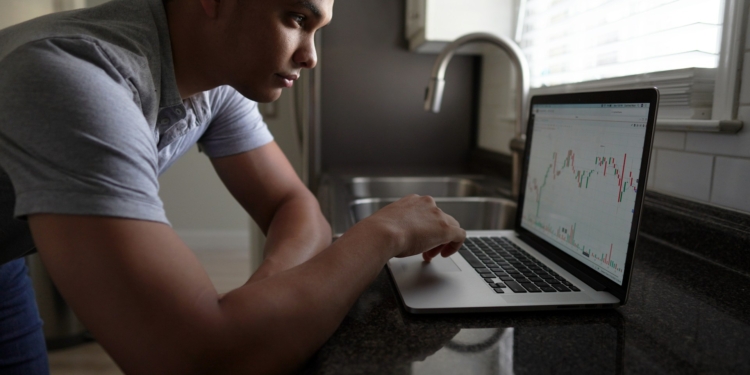 man computer laptop crypto investeerder aandelen koers