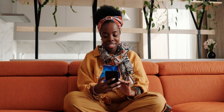 vrouw bank zitten thuis telefoon smartphone huis thuis