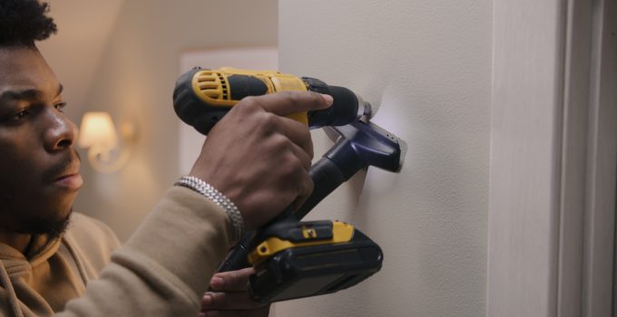 African American man drills hole in wall