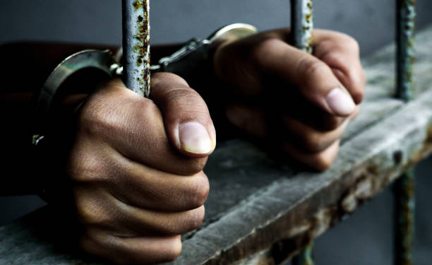 Prisoner holding metal cage in jail no freedom concept