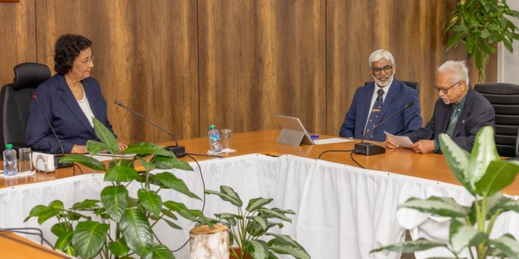 President Jennifer Simons overhandigt de eerste Geologische Atlas van Staatsolie aan pionier en oud directeur Eddy Jharap op het Kabinet van de President.