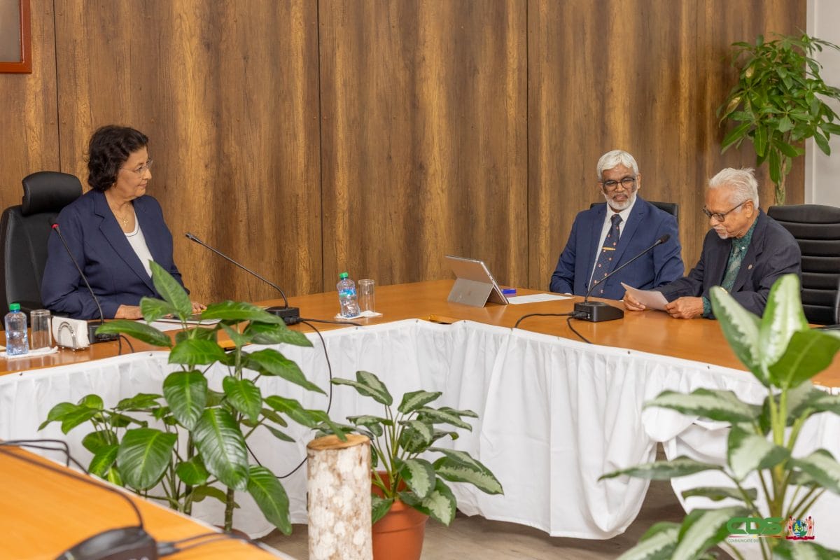 President Jennifer Simons overhandigt de eerste Geologische Atlas van Staatsolie aan pionier en oud directeur Eddy Jharap op het Kabinet van de President.