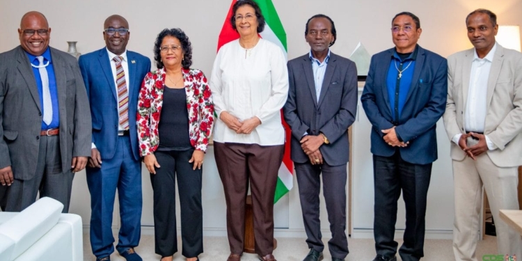 President Jennifer Simons poseert met Edgar Dikan, Armand Jurel, Theresia Cirino, Mike Nerkust, Martin Misiedjan en Sarwan Ramai