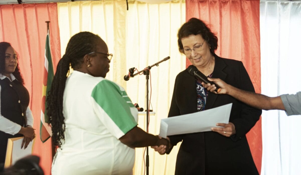 President Jennifer Simons reikt gronddocumenten uit aan verpleegkundigen en leerkrachten bij het ministerie van GBB