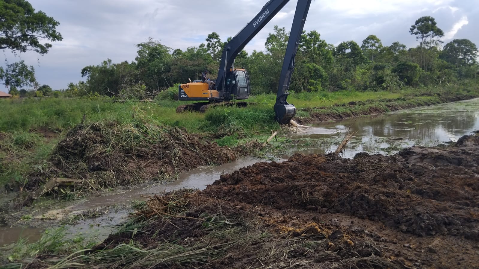 Medewerkers van het ministerie van LVV voeren werkzaamheden uit aan de natte infrastructuur in Wanica/Lelydorp om de waterafvoer te verbeteren.