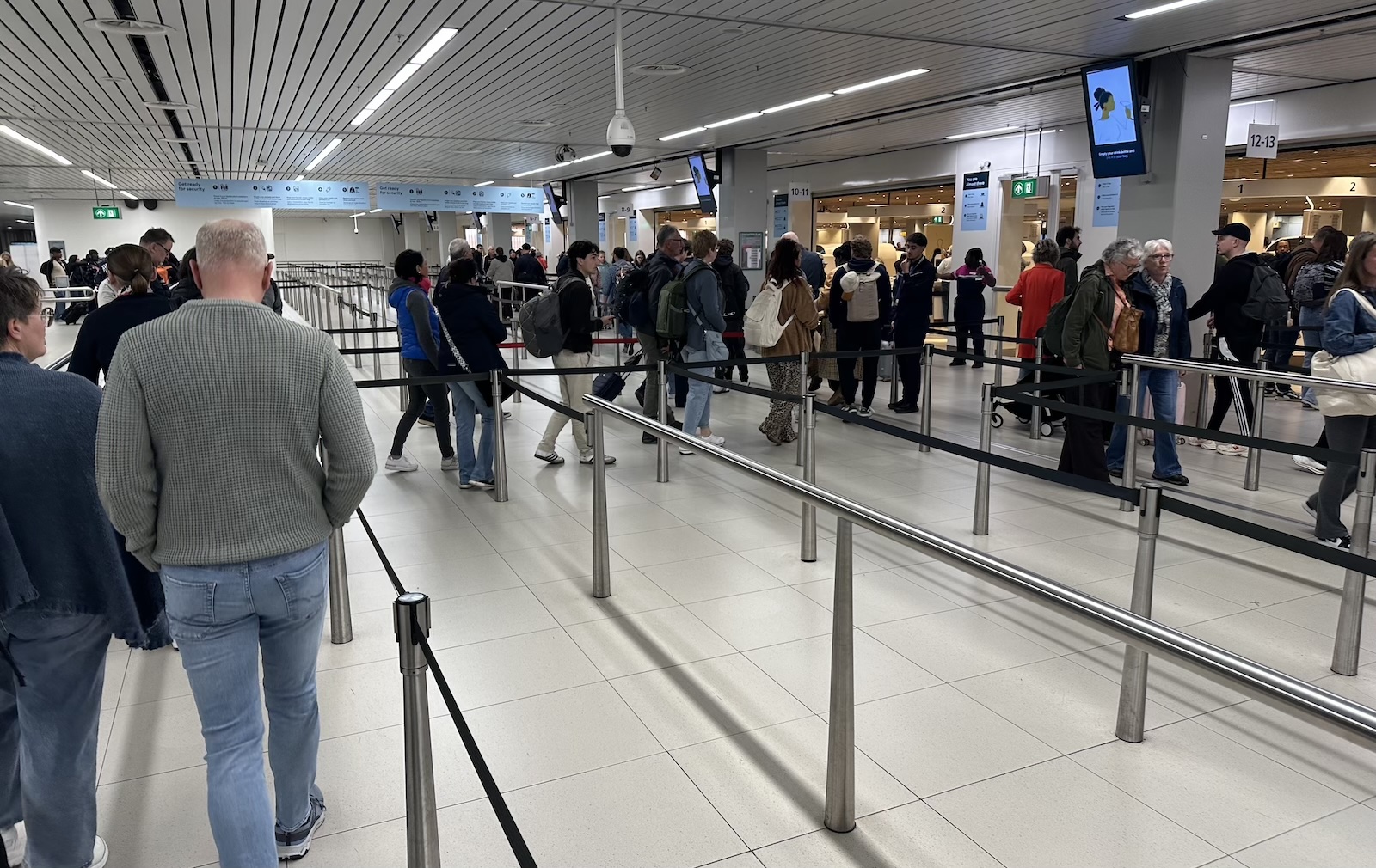Op routes van acht tot twaalf uur, zoals Nederland naar Suriname, vallen de beperkingen van economy extra op. Foto: Schiphol security check