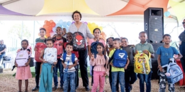 President Jennifer Simons overhandigt in Nieuw Nickerie een schoolpakket aan een van de kinderen die voor het initiatief in aanmerking kwamen. Foto: CDS